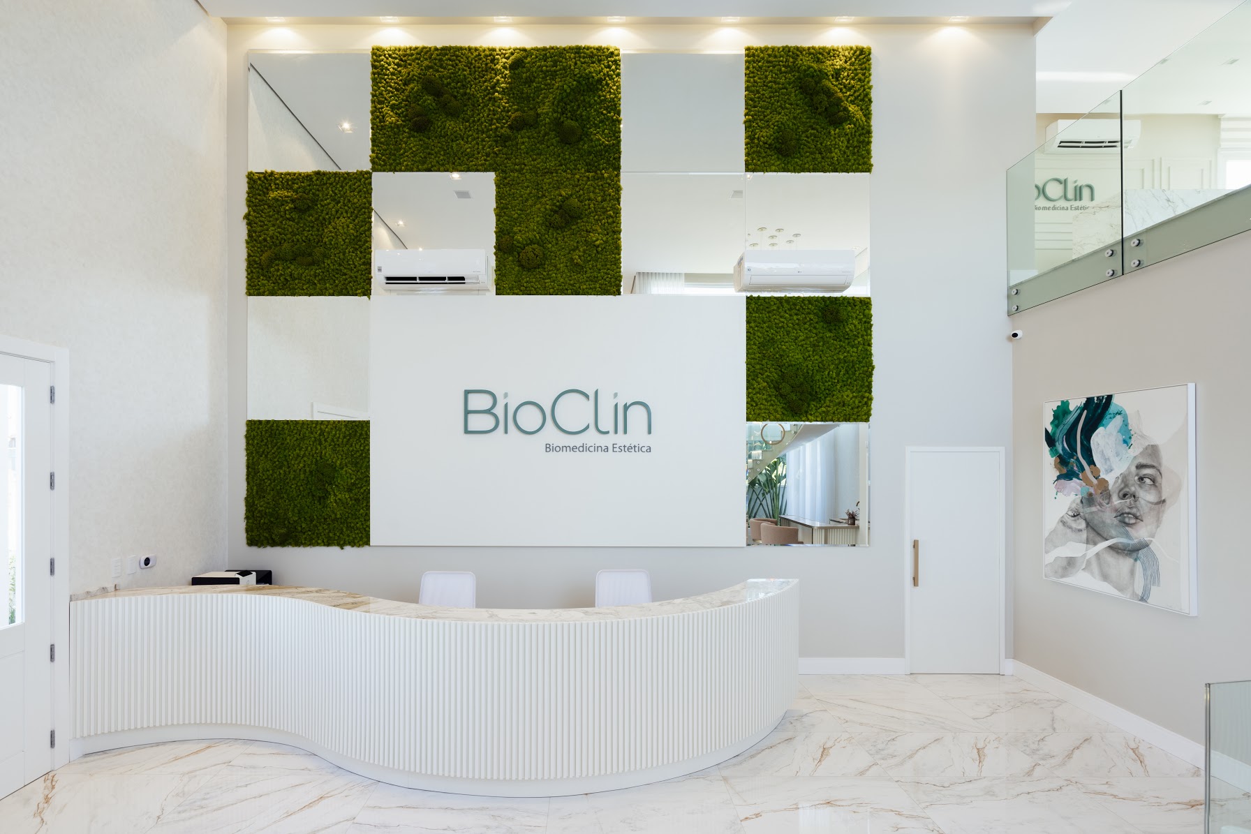 Recepção da Bioclin com parede de musgo e balcão em mármore